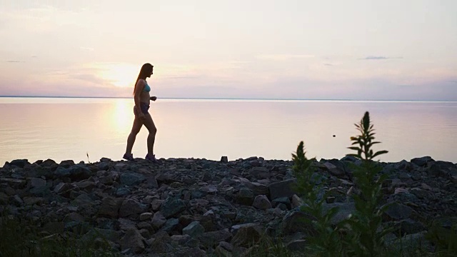 日落时分在海滩上跑步的慢镜头视频下载