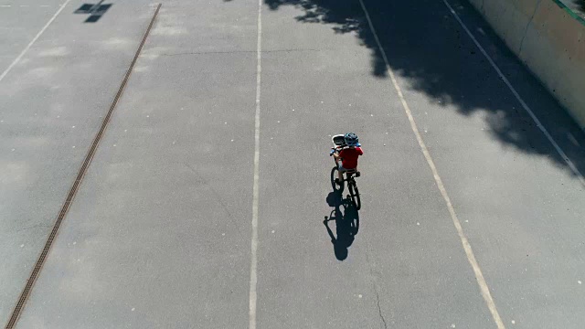 鸟瞰年轻的自行车手在空的体育场骑自行车视频下载