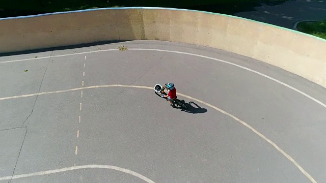 鸟瞰图的小男孩骑他的自行车在体育场视频下载