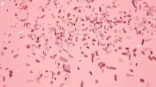 抽象的红色或玫瑰金五彩纸屑落在淡粉色的背景上。视频素材