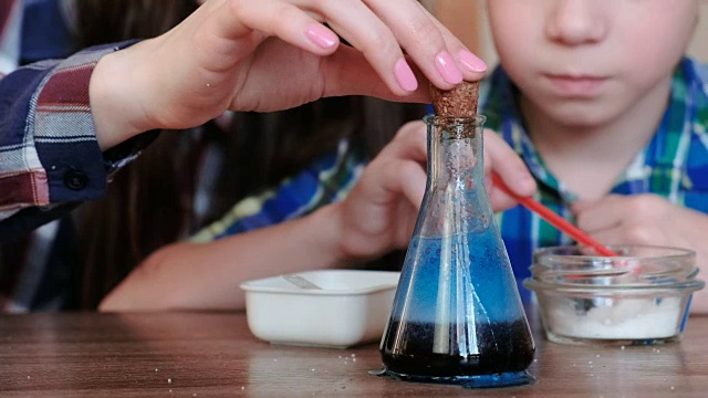 在家做化学实验。妈妈和儿子对烧瓶里的气体产生了化学反应。视频下载