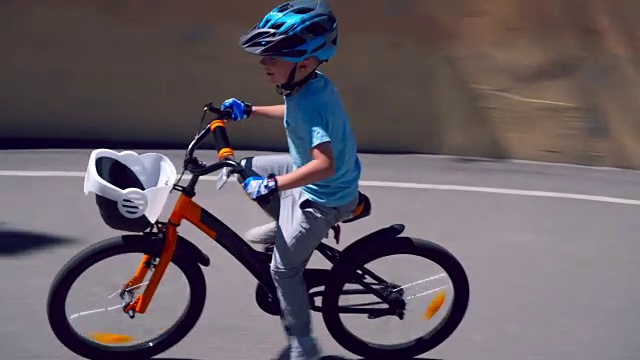 一个男孩戴着头盔在体育场骑自行车视频下载