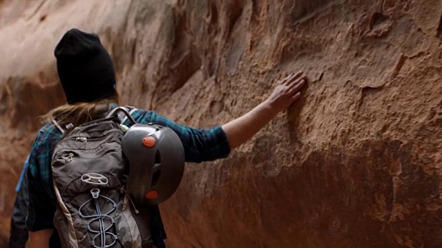 年轻女子沿着崎岖的砂岩壁槽峡谷徒步旅行冒险与朋友。视频素材