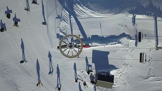 正上方拍摄的人们站在雪地上转弯的滑雪缆车上视频下载