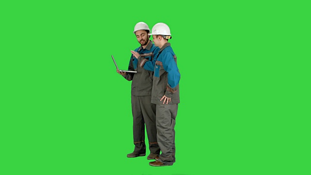 管理人员使用笔记本电脑在建筑工地的绿色屏幕上，色度键视频素材