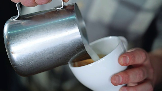 咖啡师在咖啡上画心形。视频下载