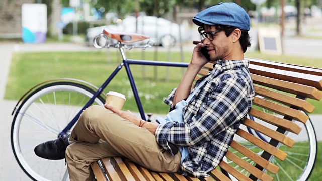 一名男子坐在街道长凳上用智能手机打电话视频素材