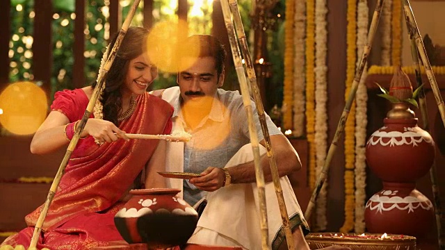 在印度新德里的pongal节日期间，丈夫和妻子在院子里烹饪食物并闻它视频素材