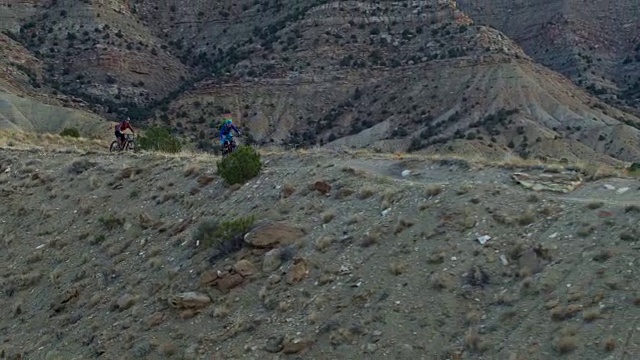 航拍的两个山地自行车手沿着山脊在18路Fruita，科罗拉多州视频素材