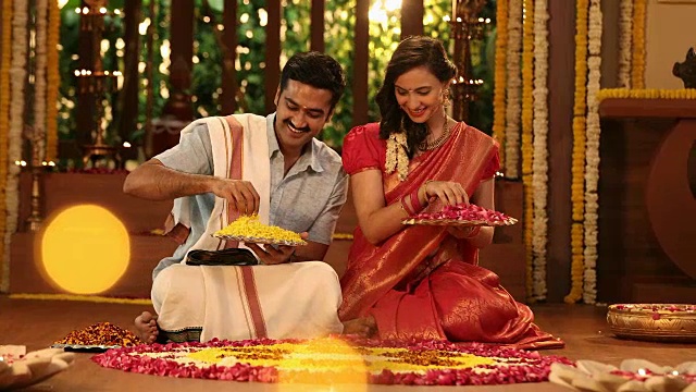 丈夫和妻子在印度新德里的蓬加尔节上穿着传统服装制作花莲果视频素材