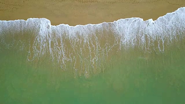 环抱绿松石海浪到达海岸线的鸟瞰图。从俯视图看，美丽的热带海滩。暑假放假概念。视频素材