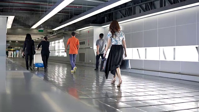 乘客们穿过通往素万那普国际机场候机楼的走道。4 k的视频视频下载