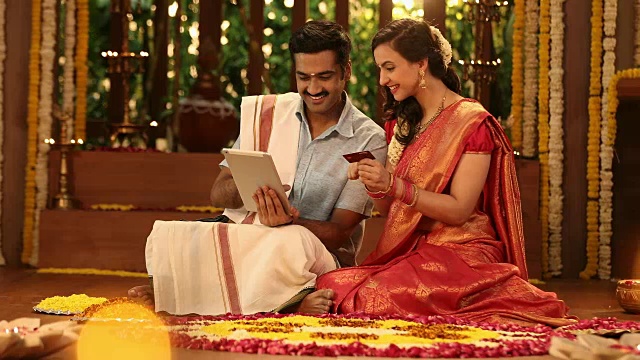 这对夫妇在印度新德里的pongal节期间通过数字平板电脑刷卡网购视频素材