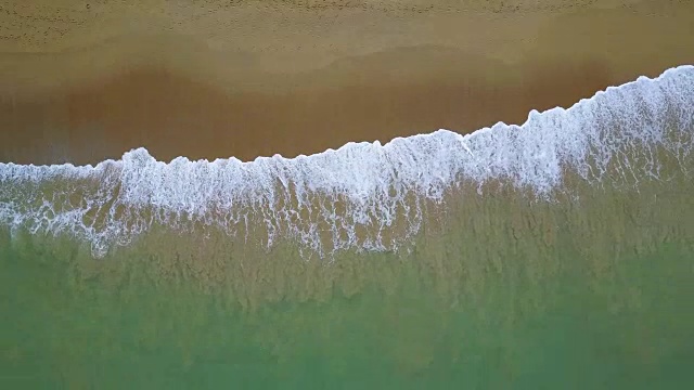 环抱绿松石海浪到达海岸线的鸟瞰图。从俯视图看，美丽的热带海滩。暑假放假概念。视频素材
