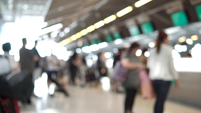 模糊画面显示，国际机场航站楼的乘客走向值机柜台。带有散焦效果的4K视频。视频素材
