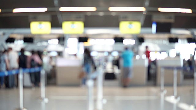 模糊画面显示，国际机场航站楼的乘客走向值机柜台。带有散焦效果的4K视频。视频素材