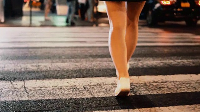 近距离观看年轻时尚的女人与购物袋过马路在纽约，美国市中心在晚上视频素材