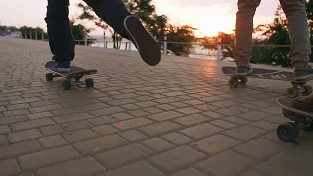 清晨一群年轻人在海边的路上玩滑板，近景拍摄视频素材