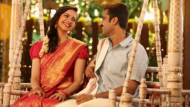 丈夫和妻子坐在一起荡秋千在pongal节/新德里，印度德里视频素材