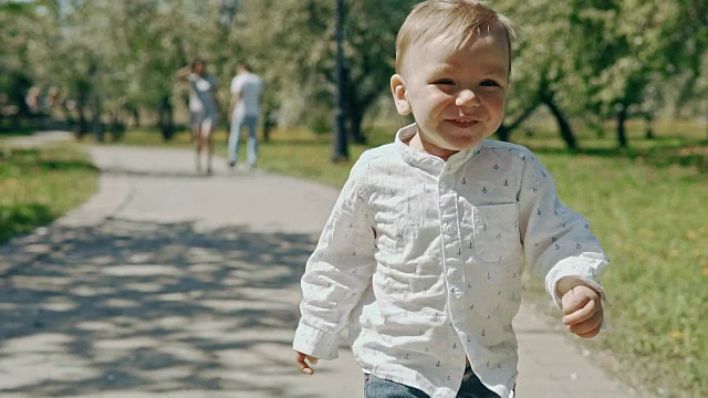 小男孩从父母身边跑开。慢镜头里的幸福家庭视频素材