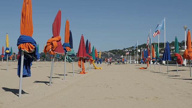 五颜六色的阳伞在著名的电影节城市的海滩上用太阳防护缓慢倾斜的镜头视频下载