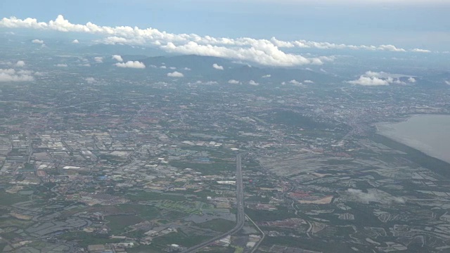 4K剪辑镜头看窗外的飞机，可以看到河边的稻田和天空的云，交通概念视频素材