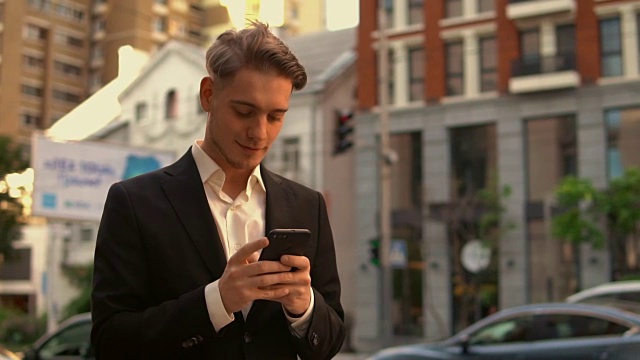 微笑的商人在城市使用手机视频素材