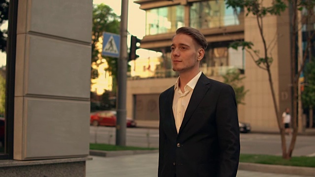 英俊的男人走在现代化的城市里视频素材