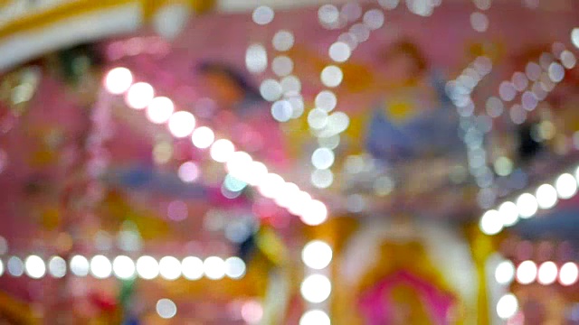 彩色模糊的快乐背景与散焦粉色旋转木马和灯光视频下载
