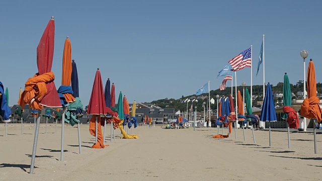 木制栈道和五颜六色的阳伞排成一排，在美国著名的电影节城市的海滩上取景视频下载