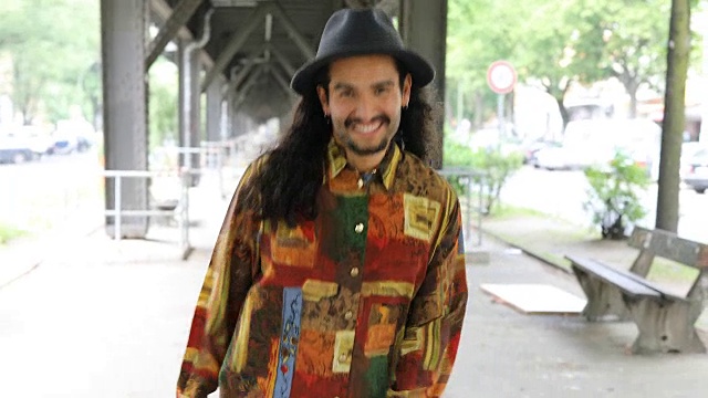 一个微笑的男人走在人行道上的肖像视频素材