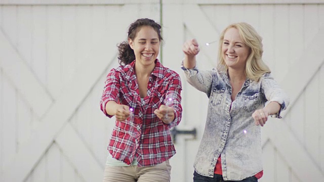 两个年轻的女人挥舞着烟花视频下载