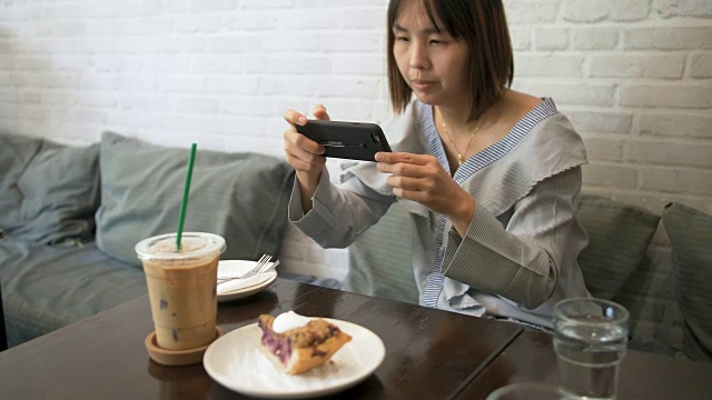 年轻女子在咖啡厅用手机视频素材