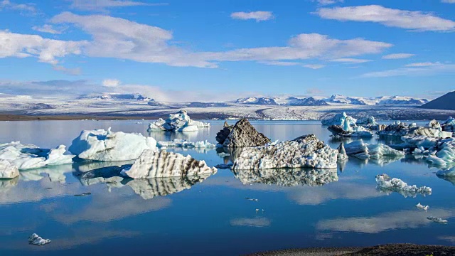 4k时间移动的云与蓝色冰山漂浮在Jokulsarlon冰湖，冰岛视频素材