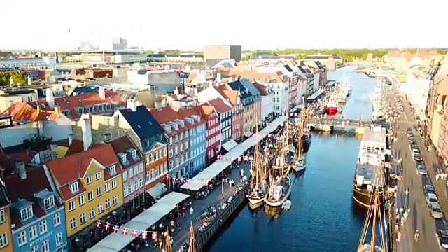 丹麦哥本哈根日落画面。尼哈芬新港口运河和娱乐区。从顶部鸟瞰的视频片段。摄像机绕圈旋转。夕阳金色时光的光芒。视频素材