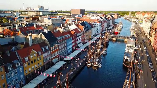 来自丹麦哥本哈根的日落视频。尼哈芬新港口运河和娱乐区。从顶部鸟瞰的视频片段。摄像机绕圈旋转。夕阳金色时光的光芒。视频素材
