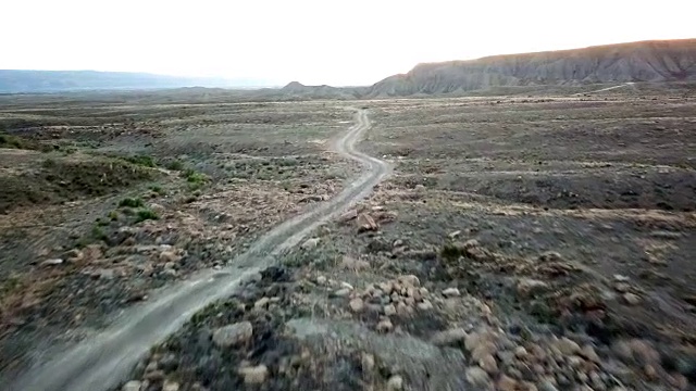 无人机拍摄的黄昏时一条蜿蜒的沙漠土路视频素材