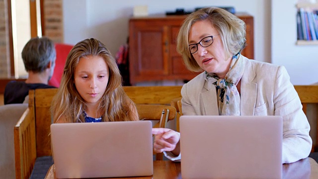 母女在使用4k笔记本电脑的同时互动视频素材