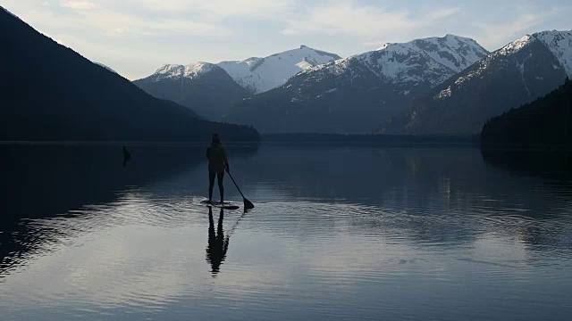 女子站起来划水板在一个原始的山湖视频下载