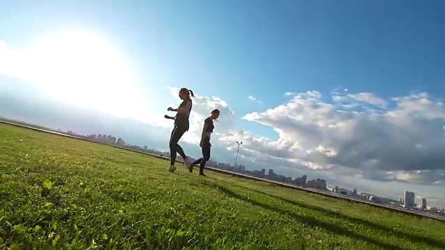 夏日日落时，年轻女子在草地上表演体操元素视频下载