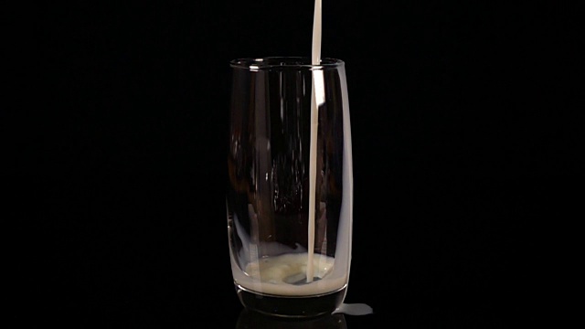 把牛奶倒进玻璃杯里。缓慢的运动。视频素材