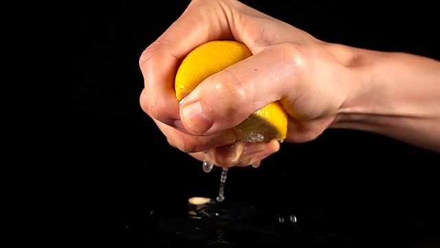 超级慢动作挤柠檬汁。视频素材