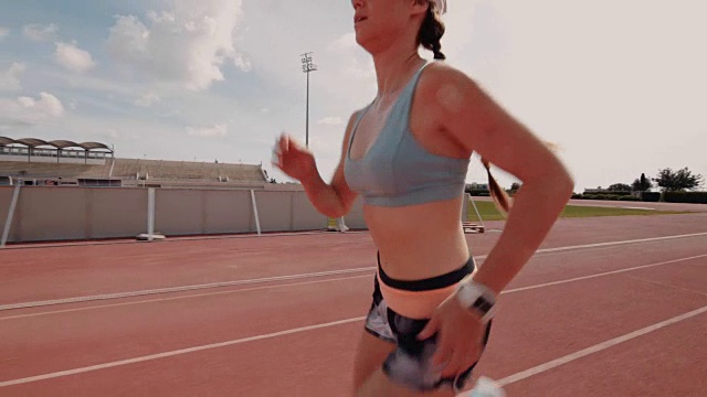 年轻健康的女人在运动轨道上锻炼和跑步视频素材