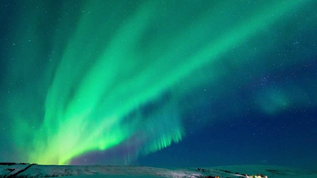 4K时移强烈明亮的北极光在被雪覆盖的冰岛北部的山上视频素材