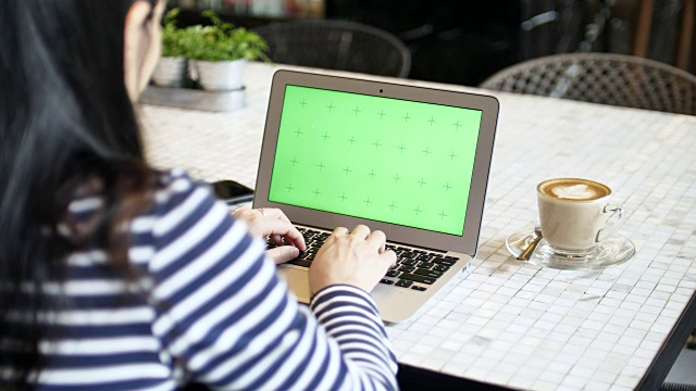 在咖啡厅使用绿色屏幕的笔记本电脑视频素材