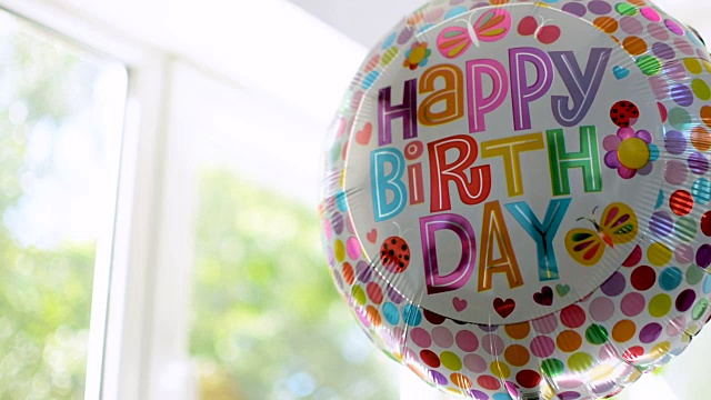 生日派对氦气气球的特写，明亮的阳光背景视频素材