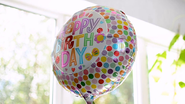快乐的生日派对气球反映周围的生机勃勃的文字视频下载