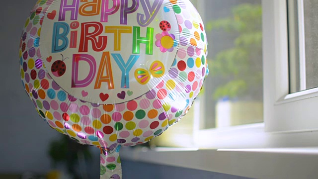 欢乐生日派对庆祝气球在窗口旋转反射阳光视频素材