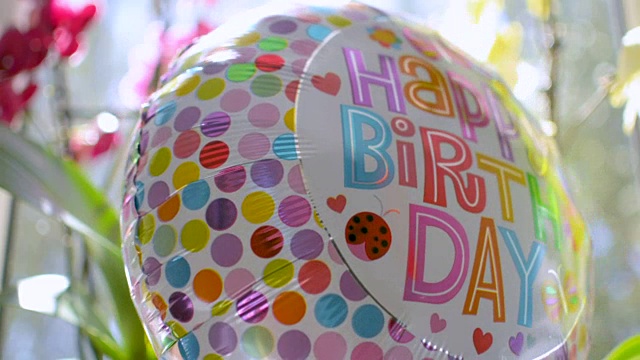 快乐的生日气球离开后，派对与鲜花的背景视频素材