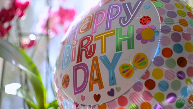 庆祝生日的礼物是鲜花和反射阳光的气球视频素材